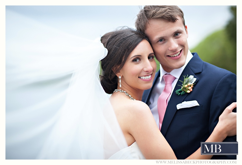 bride and groom smiling with long flowing veil